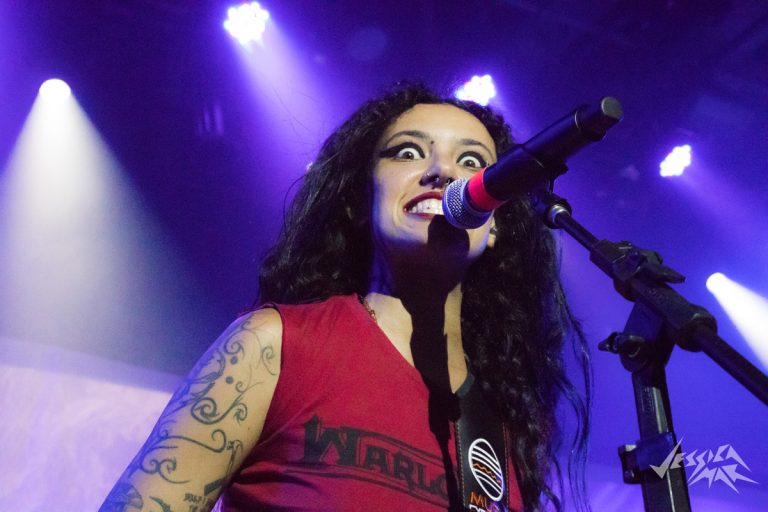 Conhecida e conhecedora da cena do metal underground, Fernanda Lira mescla energia e agressividade em sua maneira de tocar e se portar no palco.